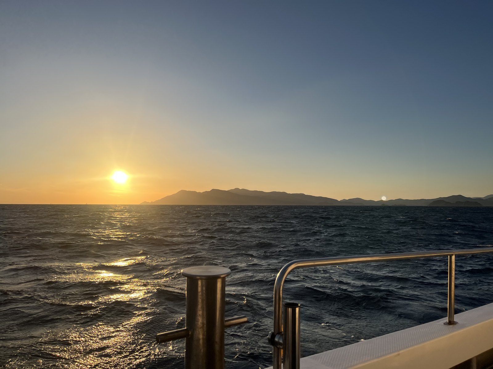 夕日を背に出船する船から見た宿毛湾の海面