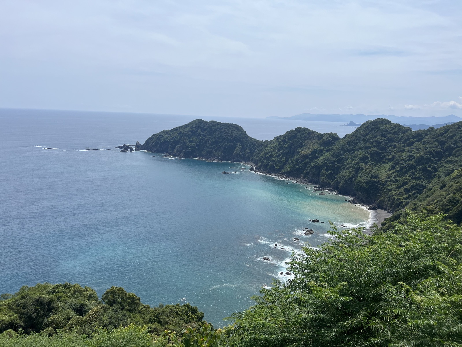 高台から見下ろした入り江。砂浜と岩場が見えるが、そこへ降りる道がない