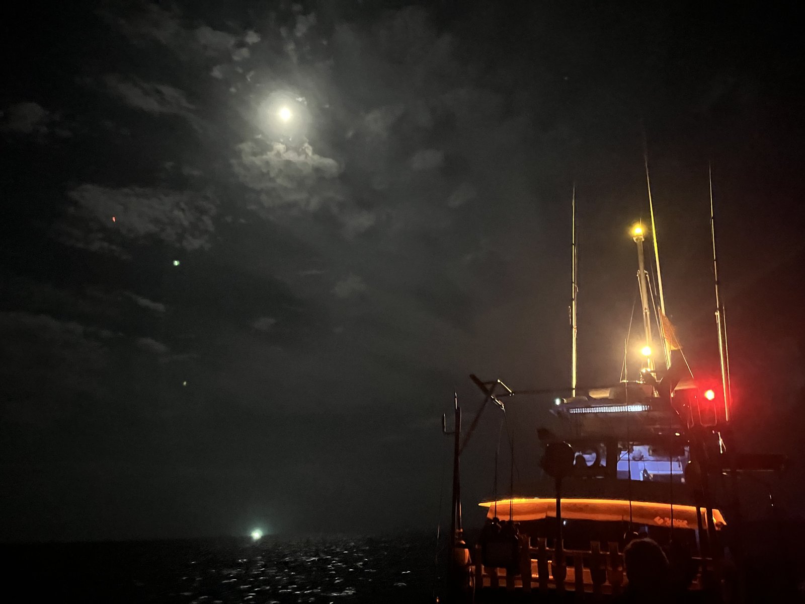 満月に近い月が出た夜のイカメタル船と集魚灯