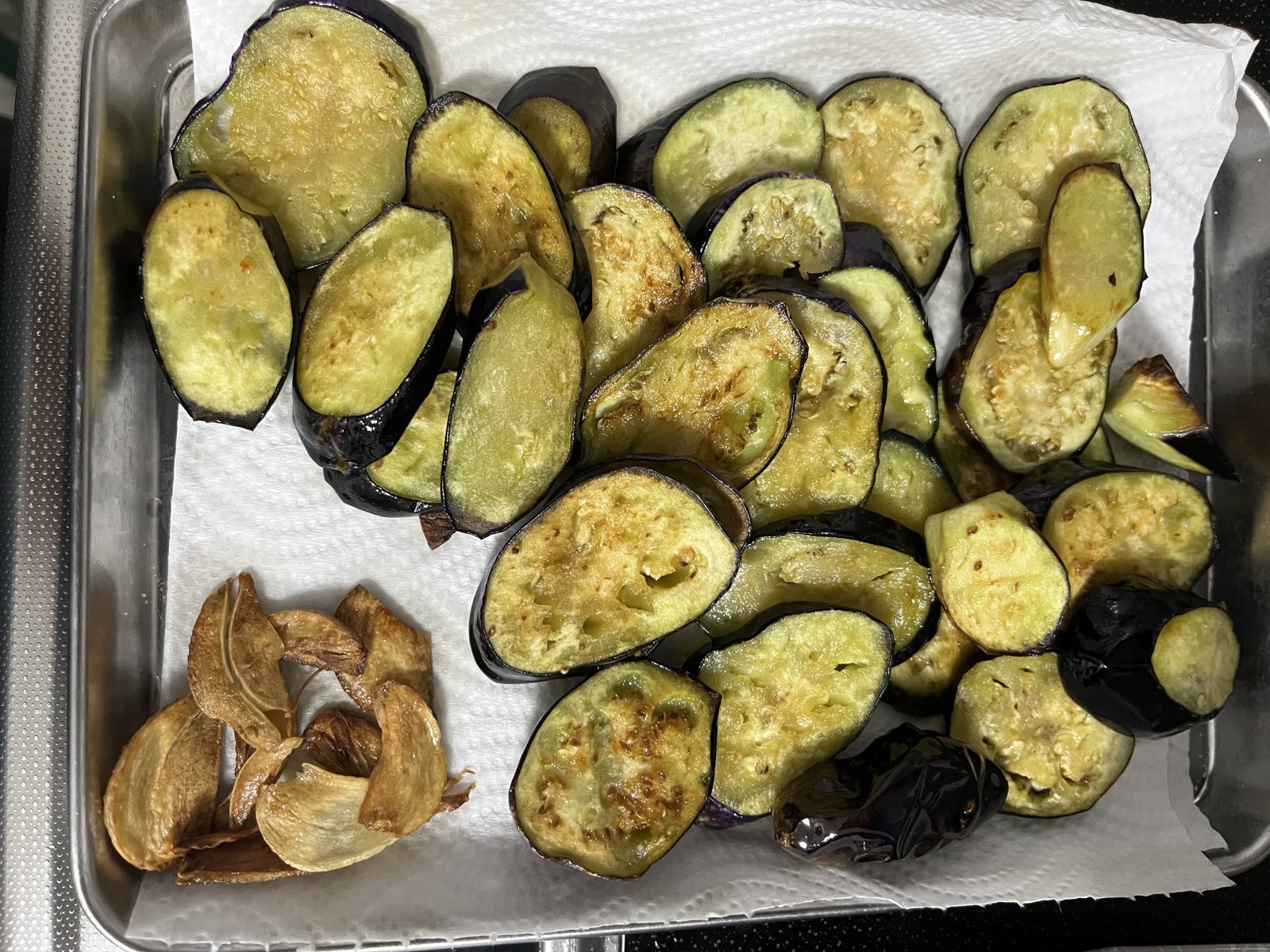 バットに並べた揚げ上がりの茄子と揚げニンニク