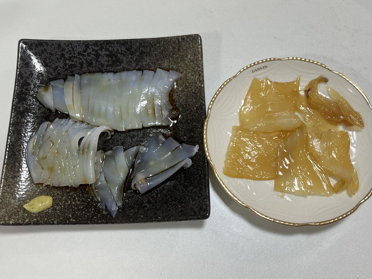 皿に盛った生のイカの刺身と沖漬けの刺身